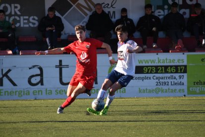 Dos jugadors es disputen una pilota en una jugada del partit que va enfrontar l’Alpicat i el Sant Ildefons.