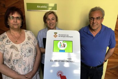 L’alcalde i dos edils, amb els dispositius per a les votacions.