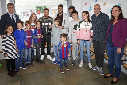 Messi i Luis Suárez, el directiu Jordi Mestre i pares i nens ahir durant la visita de jugadors del FC Barcelona a hospitals infantils.