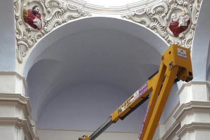 Un operari treballant ahir en la pintura de Sant Pere de Rosselló, que preveu tornar a acollir misses a partir del 3 de maig.