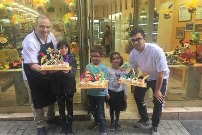 Els tres guanyadors posen amb les seues mones vora Pere Graells i el seu fill, Pere, davant de la pastisseria Graells de Balaguer, que regenten amb l'esposa de Pere, Judith Ávila