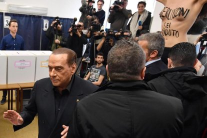 Silvio Berlusconi fue sorprendido por una activista de Femen cuando iba a depositar su voto.