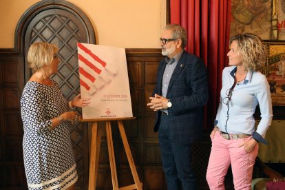 Montse Parra, Fèlix Larrosa y Montse Mínguez, ante el cartel.