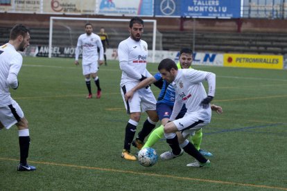 Un jugador del Borges intenta driblar un jugador de l’Igualada davant d’un company.