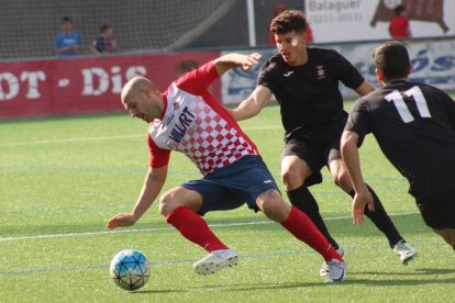 El jugador del Balaguer Adrià, autor de dos gols ahir, intenta driblar dos jugadors del Valls en una de les jugades del partit d’ahir.