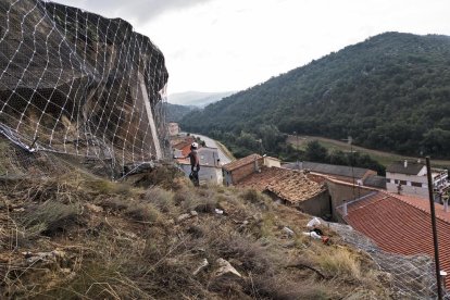 Un dels operaris revisa la malla d’acer instal·lada per subjectar les roques a Biosca.