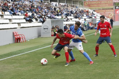 Javi López lluita una pilota davant d’un jugador de l’Olot.