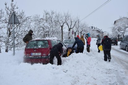 Afectats per la intensa nevada a Bellver de Cerdanya provant de col·locar cadenes als vehicles.