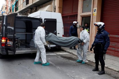 Operarios trasladan el cadáver del joven de 19 años.