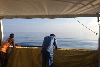 Imatge de dos dels immigrants a bord del vaixell ‘Open Arms’ rumb al port d’Algesires.