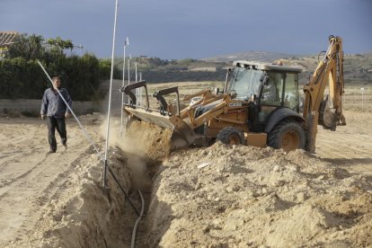 Operarios trabajando en una de las fincas del tramo de Balaguer donde se instala el regadío. 