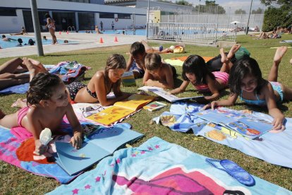 Alguns dels nens que ahir van gaudir de la bibliopiscina de les piscines municipals de Pardinyes, a Lleida.