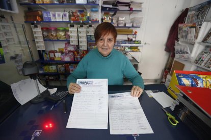 Una comerciant mostra els fulls per firmar per la iniciativa.