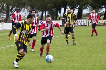 Un jugador de l’Angulària rep la bimba davant la pressió d’un jugador del Barbens.