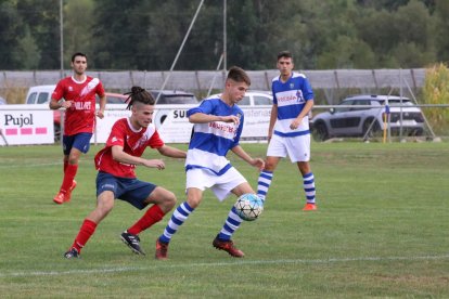 Un jugador de l’equip local intenta controlar la pilota davant la pressió dels visitants.