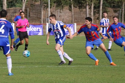 Un futbolista de l’Organyà controla la pilota davant la pressió d’un rival, en una acció del partit d’ahir.