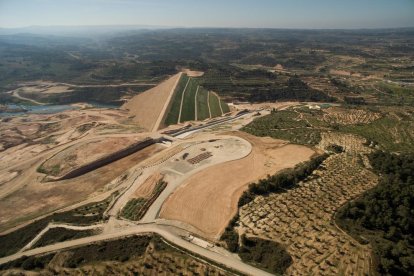 Vista aèria de la presa de l’Albagés, de terra compactada, que regula el riu Set i ja conté aigua.