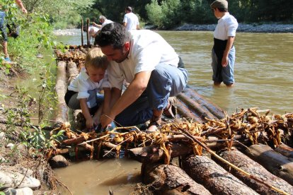 Foto de família de la vintena de raiers que han participat aquest any a Coll de Nargó en la construcció i la navegació d’aquestes barques de fusta.