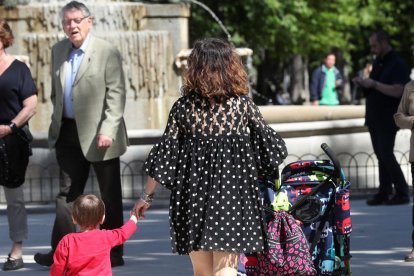 Una dona passeja amb el seu fill de la mà.