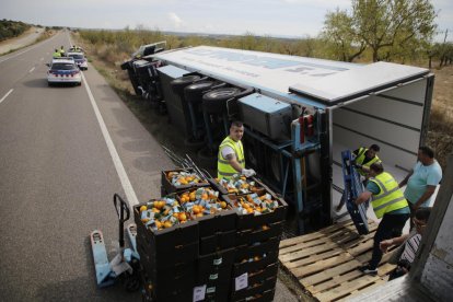 Les caixes de mandarines que portava el camió sinistrat es van carregar a un altre tràiler.