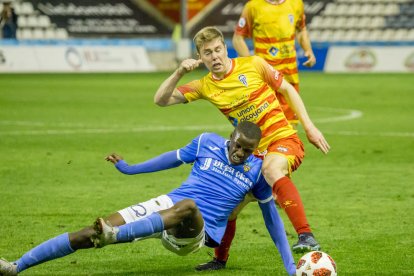 Alpha, que entró en la segunda parte, cae ante un jugador del Alcoyano en la disputa del balón.