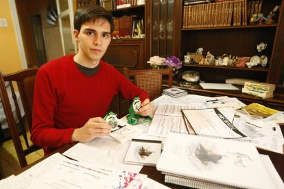 Adrià Ibáñez, con las medallas que ganó en la feria Mostratec de Brasil, frente a la mesa con los libros, los CD’s y los dibujos de su proyecto.