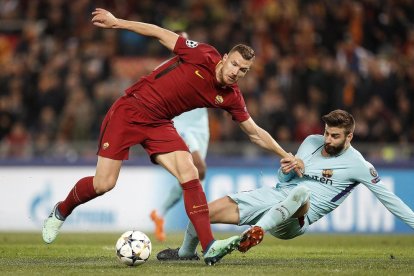 Gerard Piqué comete un claro penalti al agarrar a Edin Dzeko, una acción que permitió al capitán romano De Rossi marcar el 2-0 en la segunda mitad.