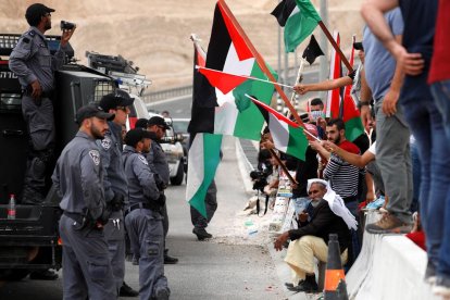 Soldats israelians davant civils palestins, ahir, a Cisjordània.