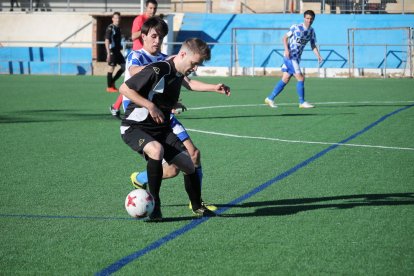 Un jugador del Brea reté l’esfèric davant de la pressió d’un del Tamarit.