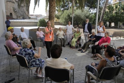 A l’esquerra, els usuaris fan exercicis amb una monitora i a la dreta, Larrosa i Mínguez, que es van unir a l’activitat.