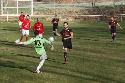 El portero del Montoliu aleja el balón ante la presión de los jugadores del Coll de Nargó.