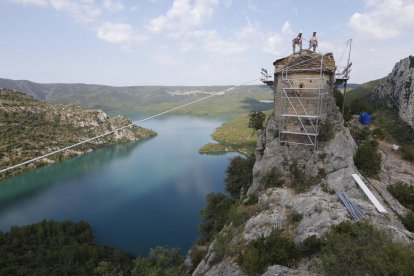 Los operarios trabajando en la cubierta del templo, con las aguas del Noguera Ribagorçana a la izquierda de la foto. 