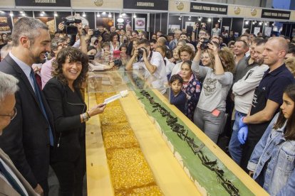 La consellera de Agricultura, Teresa Jordà, presidió el reparto de las dos barras gigantes de turrón, de 250 kg cada una, de Torrons Vicens.