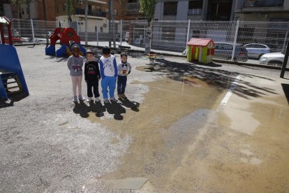 Un grupo de niños de P-3 en el anegado patio de la escuela Joan Maragall.