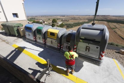 Operaris instal·lant els contenidors de recollida selectiva al costat dels vells en una de les illes delimitades per l’ajuntament d’Alfés.