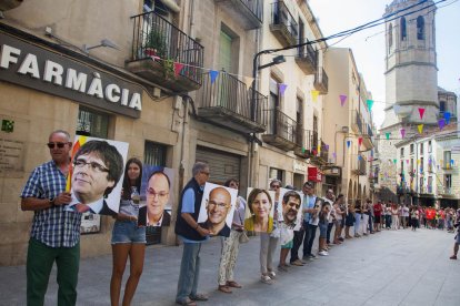 Participants en la cadena humana amb fotos de líders independentistes presos i a l’estranger.