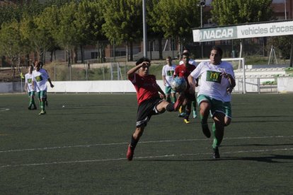 Un jugador del Coll controla la pilota davant de la pressió rival.