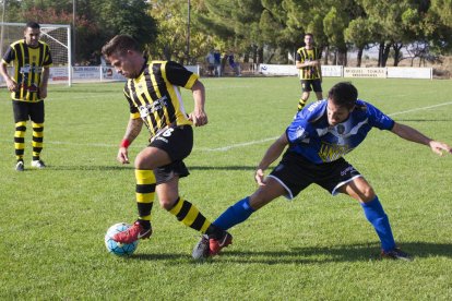 Un jugador de l’Angulària controla la pilota davant un jugador del Solsona B. 