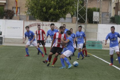 Un jugador del Puigvertenc intenta controlar el balón entre la defensa del Alcarràs B.