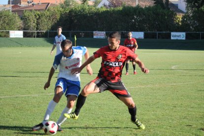 Un jugador del Tamarit controla la pilota davant de la pressió d’un defensa del Belchite.