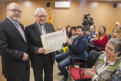 Queraltó, junto al alcalde, muestra el documento que le acredita como ‘hijo predilecto’ de Vallbona. 