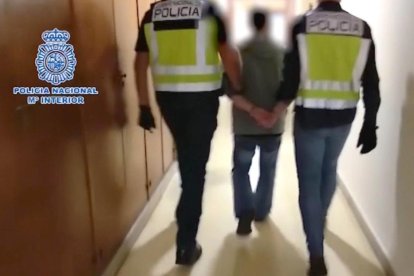 Imagen de dos agentes acompañando a César Román en su detención, ayer.