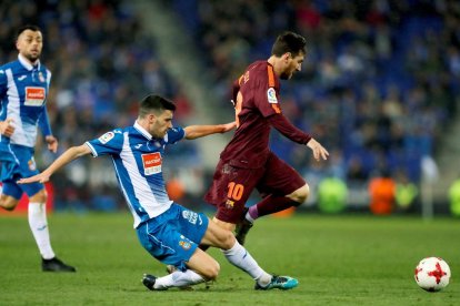 Leo Messi intenta superar l’entrada del defensa de l’Espanyol Aarón Martín en un partit gris de tot l’equip blaugrana.