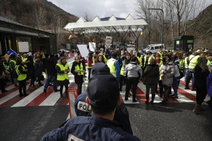 Dos policías andorranos observan cómo los huelguistas bloquean la frontera de La Farga de Moles.