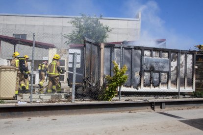 Bomberos junto al contenedor de voluminosos calcinado. 