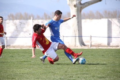 Un jugador de l’equip local i un del visitant es disputen per l’esfèric. 