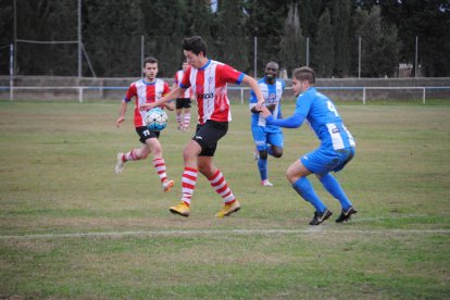 Un jugador del Pobla controla la pilota en un partit molt igualat i intens. 