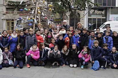 Alumnos de Maristes colaboraron ayer en la decoración del árbol en Lleida, en el décimo aniversario de la desaparición de Josep Guinovart.