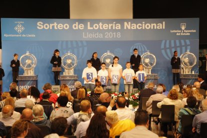 Niños de Afanoc muestran el primer premio del sorteo de ayer en la Llotja.