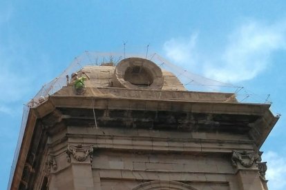 Operarios trabajando ayer en las redes de una de las torres de la Catedral.